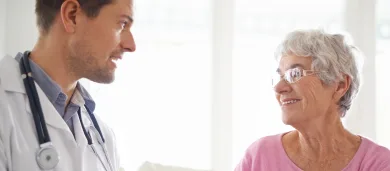 Male doctor talking to elderly female patient
