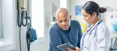 Female doctors talking to elderly male patient